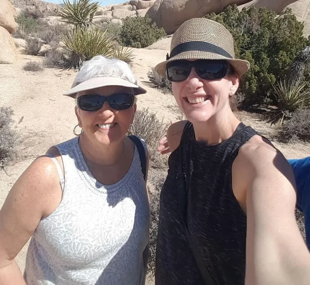 Kim and her mother hiking together, smiling in the sun